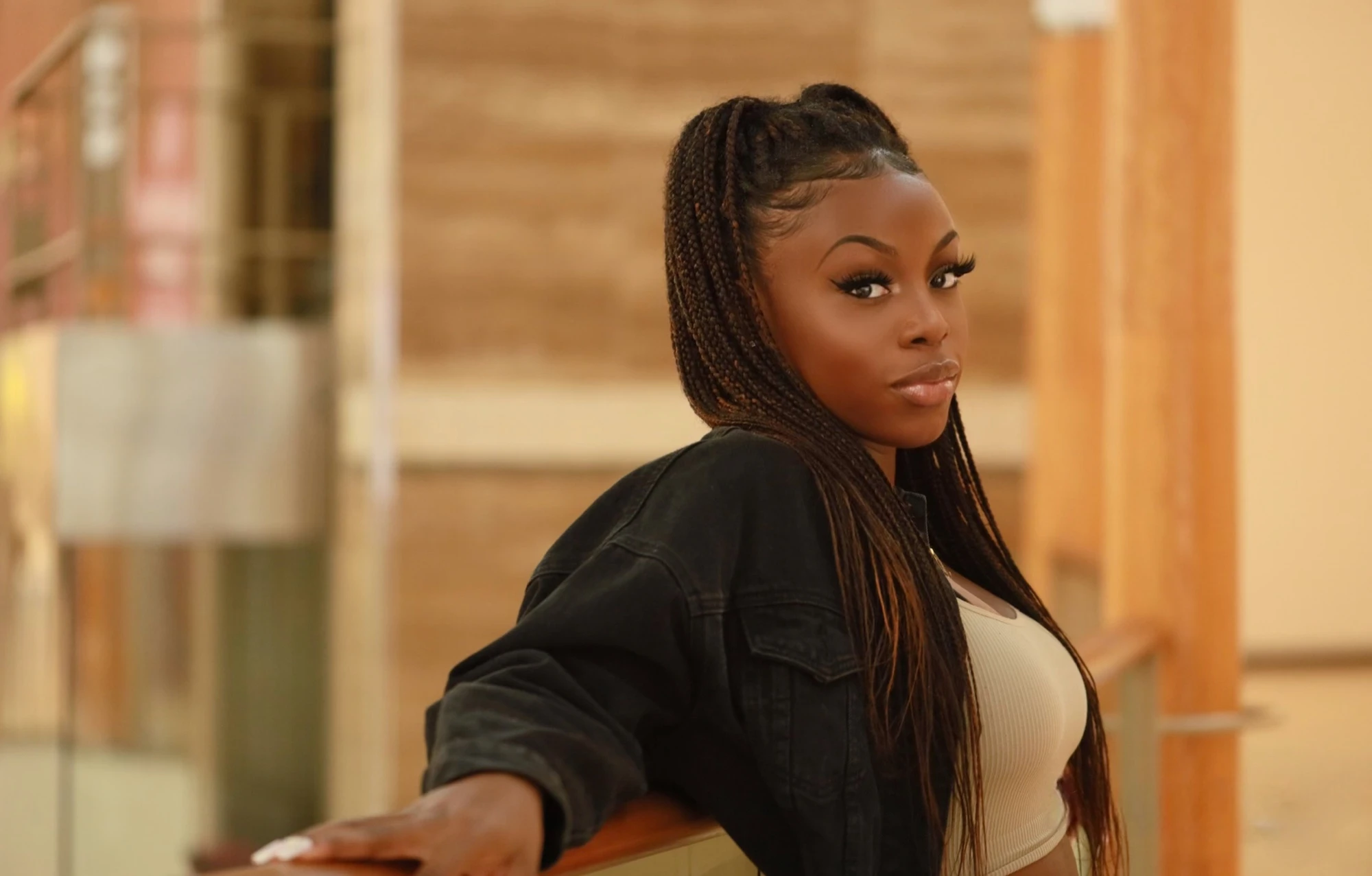 Shalom Oladele, leaning on a railing, looking back over her shoulder.